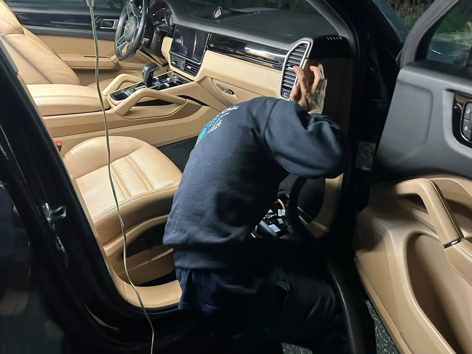 Operatore VaporChic durante la pulizia degli interni in pelle di una Porsche Operatore VaporChic durante la pulizia degli interni in pelle di una Porsche