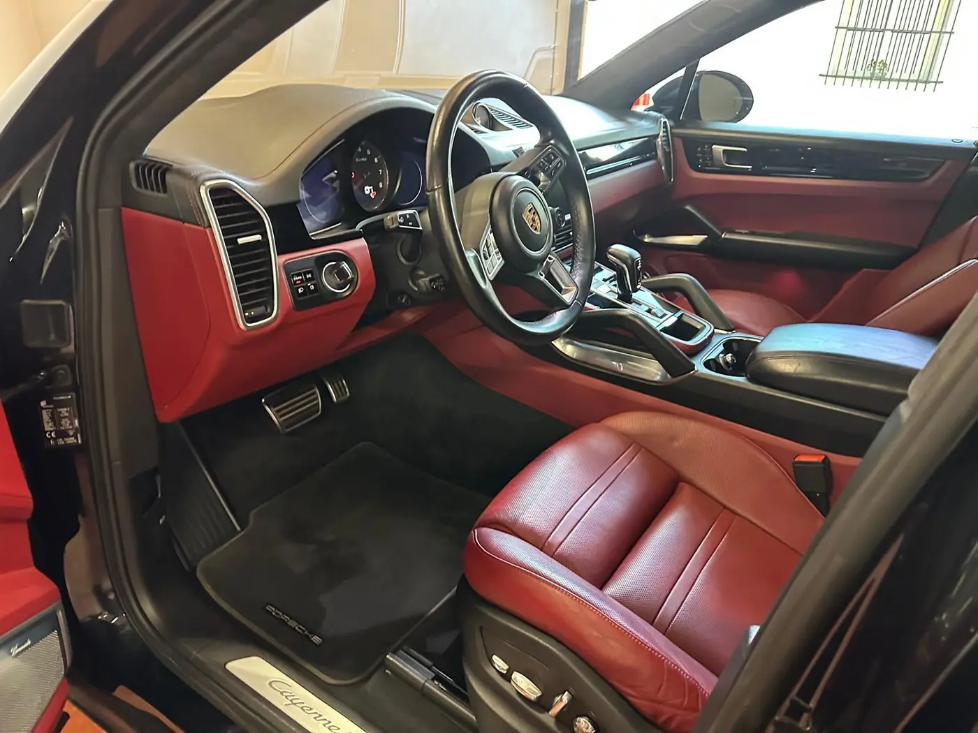 Sedile di guida in pelle rossa e tappetini di una Porsche dopo il detailing Sedile di guida in pelle rossa e tappetini di una Porsche dopo il detailing