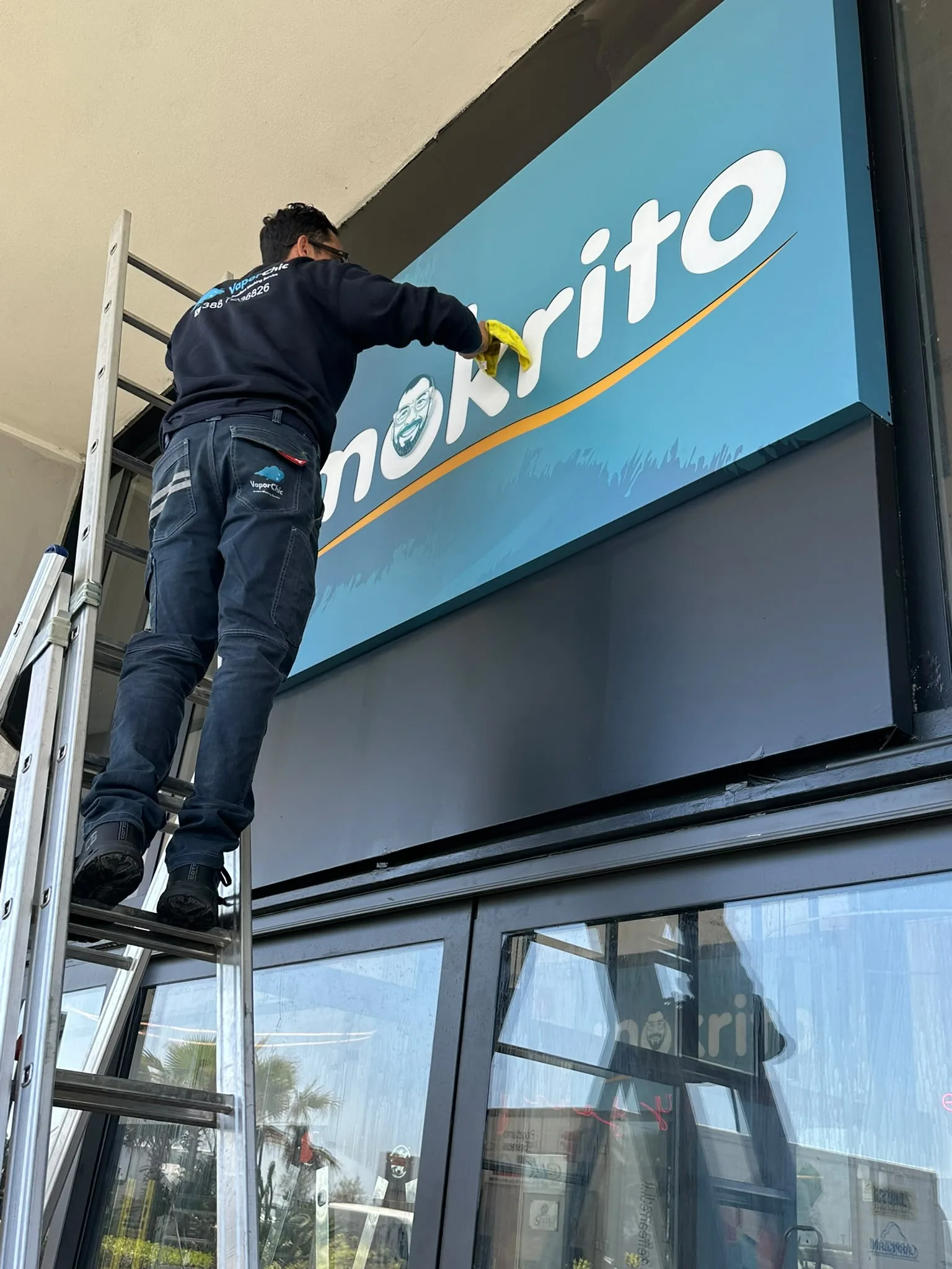 Pulizia professionale di insegna luminosa e vetrata di un locale commerciale Pulizia professionale di insegna luminosa e vetrata di un locale commerciale