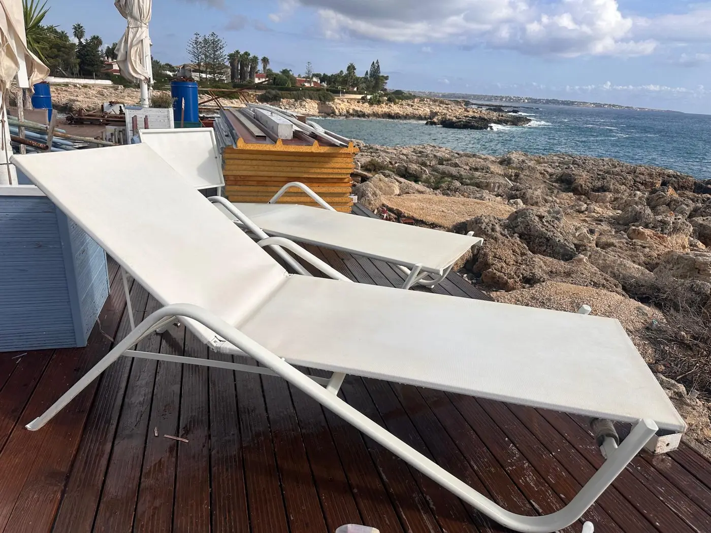 Lettino in tela sul solarium di un lido sugli scogli a Siracusa Lettino in tela sul solarium di un lido sugli scogli a Siracusa