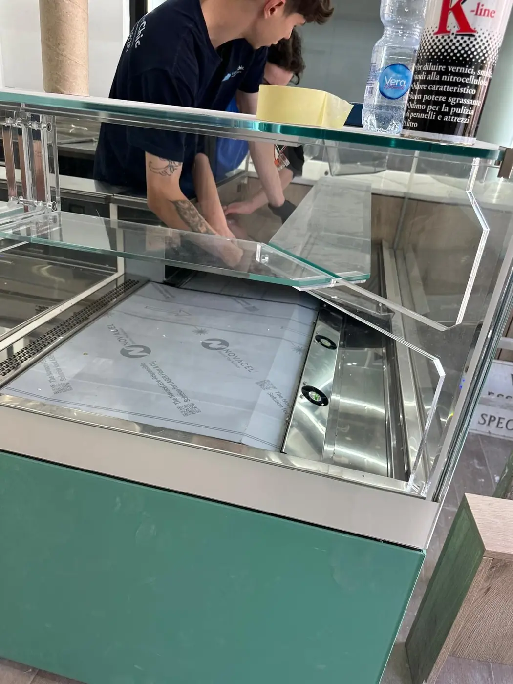 Squadra VaporChic pulisce la vetrina refrigerata del banco di un locale Squadra VaporChic pulisce la vetrina refrigerata del banco di un locale