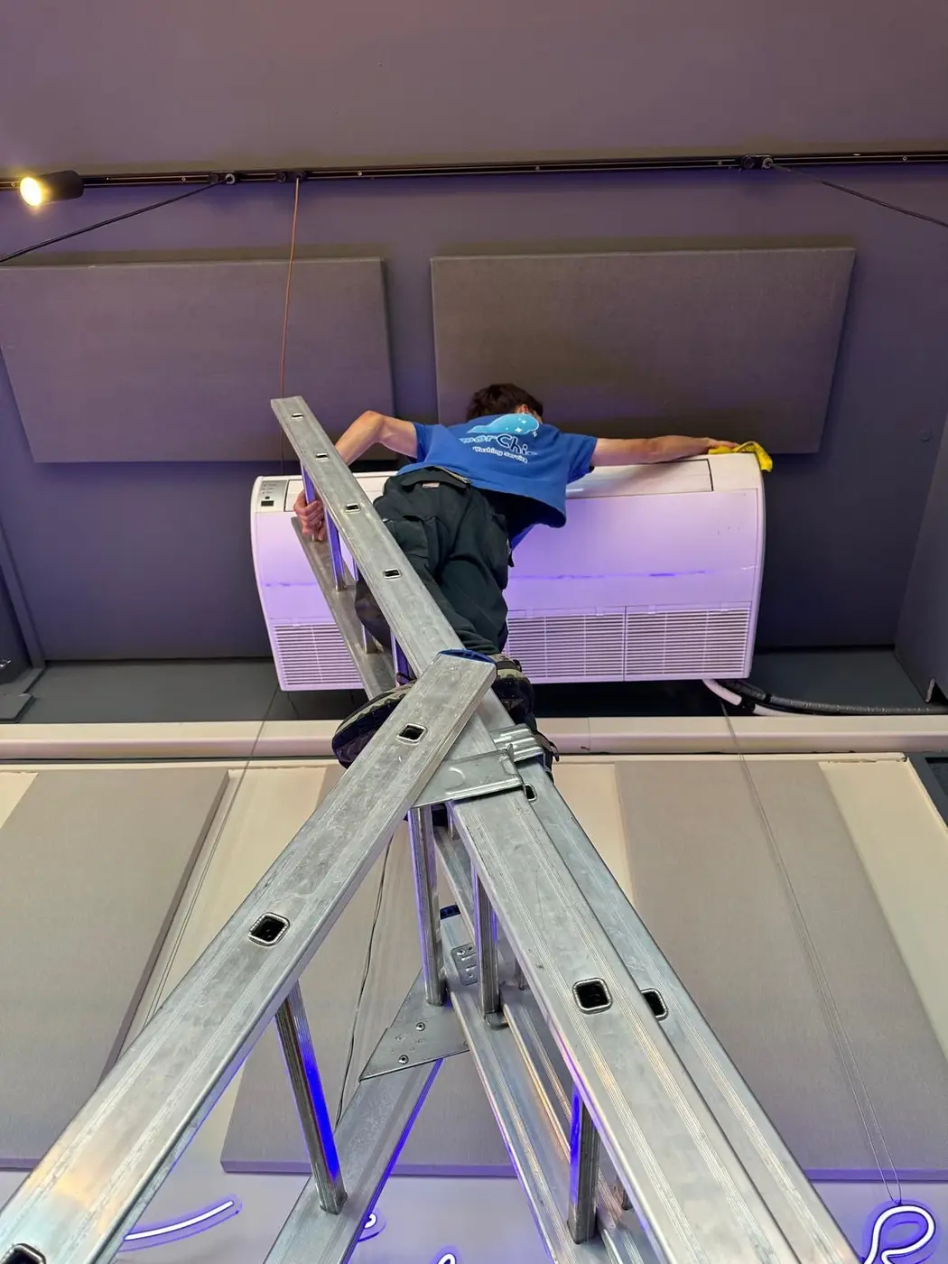 Operatore VaporChic pulisce il climatizzatore a soffitto di un ristorante Operatore VaporChic pulisce il climatizzatore a soffitto di un ristorante