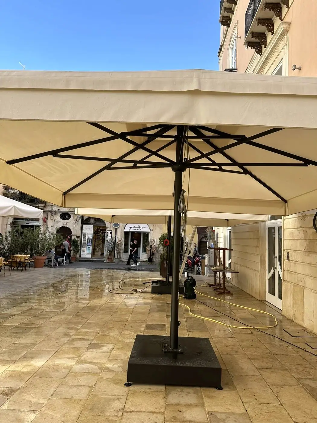 Lavaggio e smacchiatura a vapore di un grande ombrellone esterno Lavaggio e smacchiatura a vapore di un grande ombrellone esterno