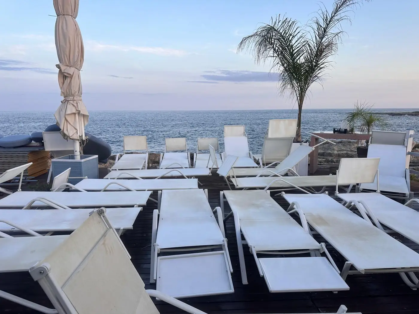 Solarium di un lido sul mare a Siracusa con i lettini da lavare a fine stagione Solarium di un lido sul mare a Siracusa con i lettini da lavare a fine stagione