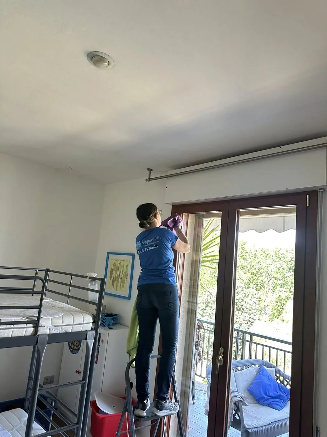 Operatore in divisa VaporChic pulisce a vapore infissi e finestre Operatore in divisa VaporChic pulisce a vapore infissi e finestre