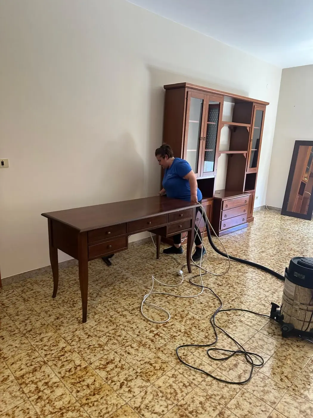 Operatrice VaporChic pulisce mobili e pavimenti di un appartamento Operatrice VaporChic pulisce mobili e pavimenti di un appartamento