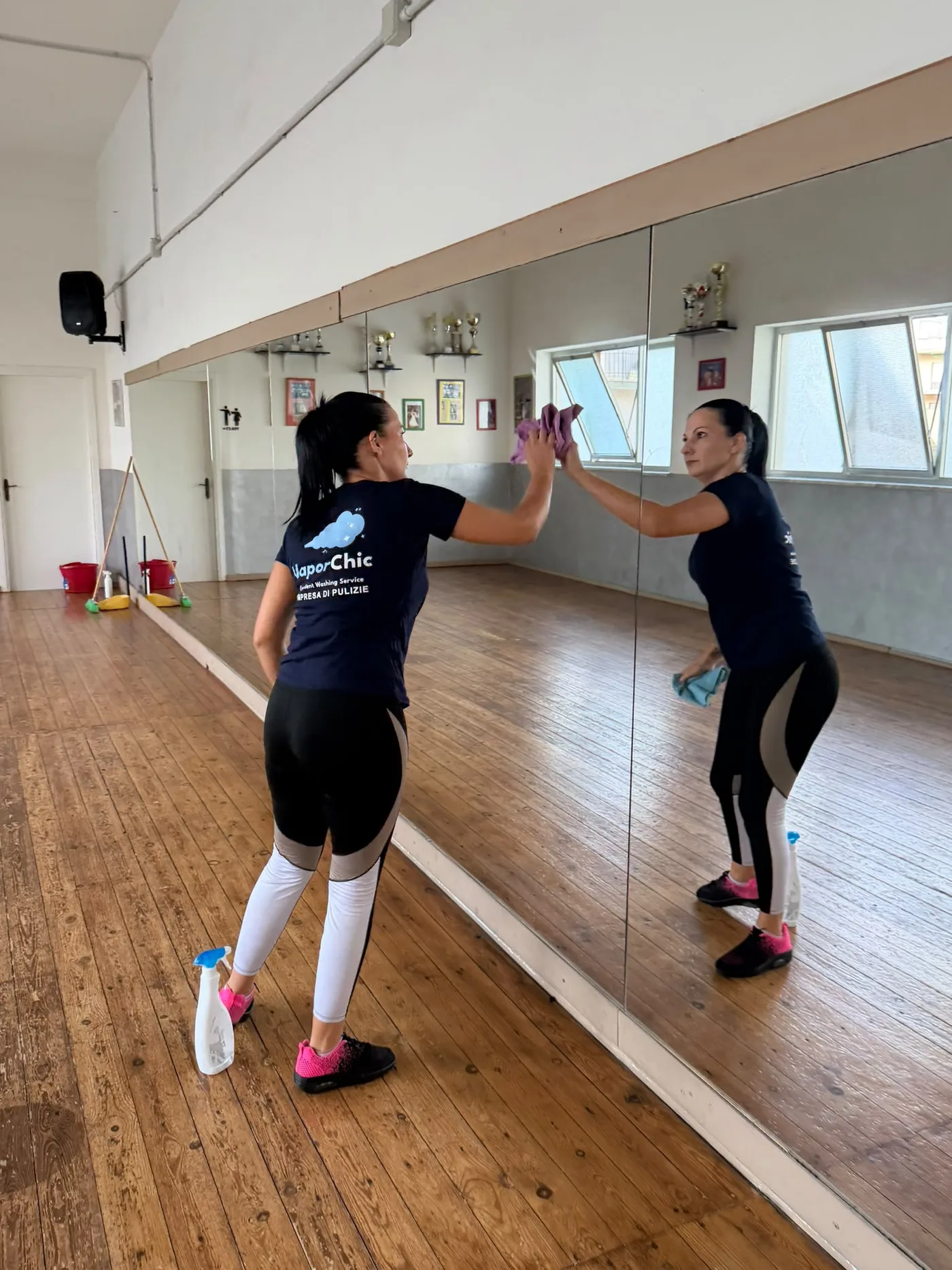 Operatrice CleanChic by VaporChic durante la pulizia delle grandi pareti a specchio e del parquet di una palestra Operatrice CleanChic by VaporChic durante la pulizia delle grandi pareti a specchio e del parquet di una palestra