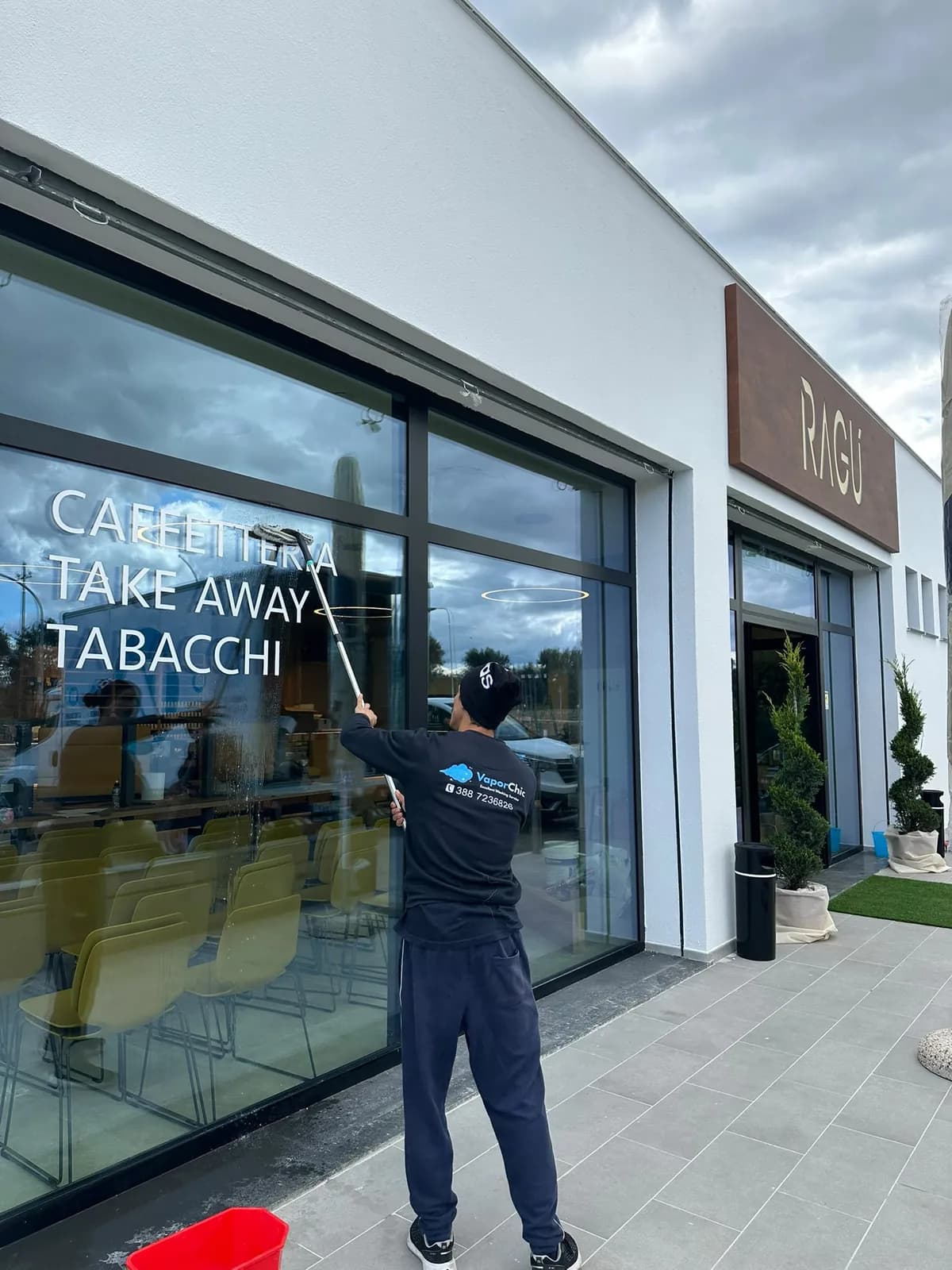 Operatore CleanChic durante la pulizia professionale delle grandi vetrate di un locale commerciale Operatore CleanChic durante la pulizia professionale delle grandi vetrate di un locale commerciale